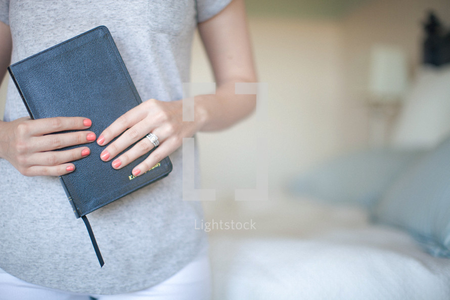 Woman holding a clsoed Bible.