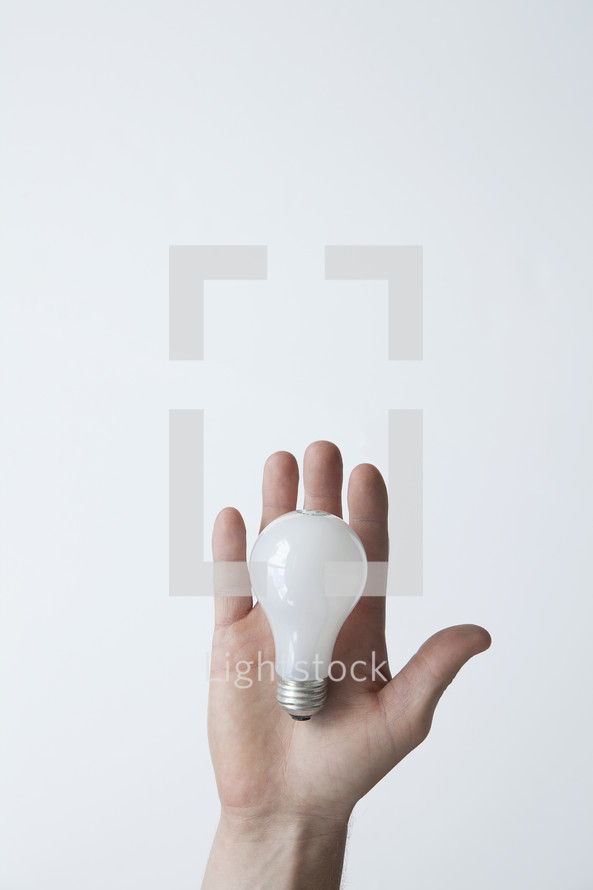 hand holding a lightbulb.