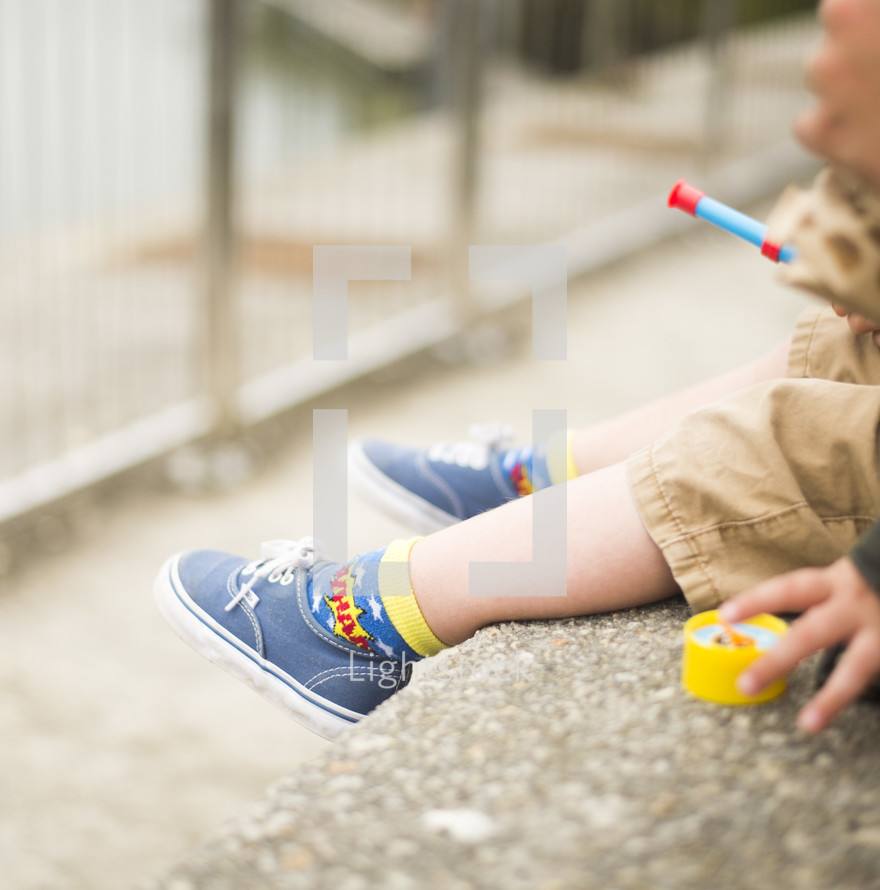 feet of a child in sneakers playing outdoors 