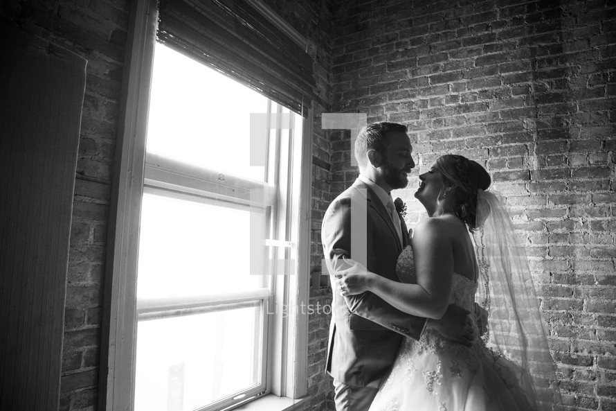 bride and groom dancing in a window 