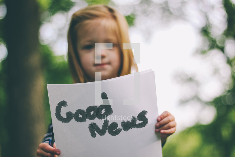 Girl holding Good News sign