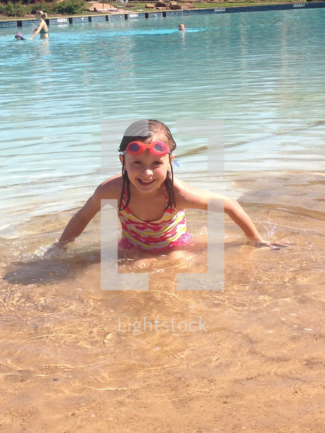 A little girl playing in water on a beach 