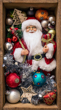 Santa figurine and ornaments in a wooden crate 