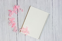 pink flower petals and blank notebooks 