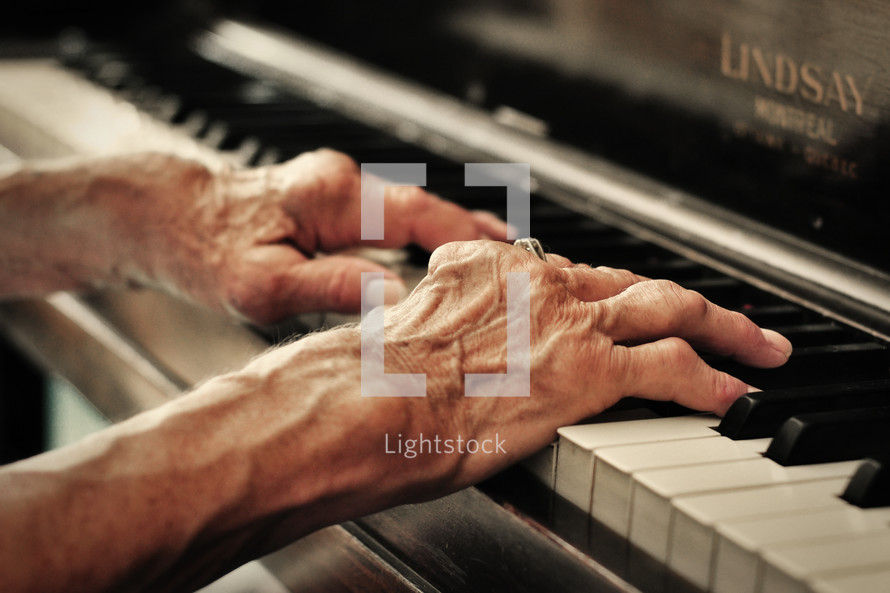 Elderly hands playing the piano.
