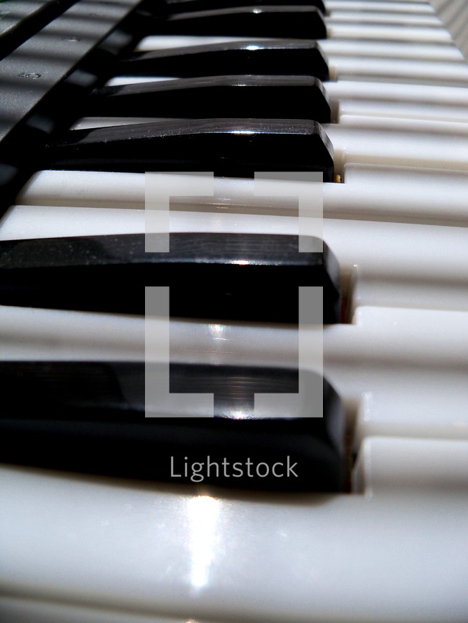 Upclose view of an electronic keyboard piano keys in black and white to make music for live praise and worship services in church, recorded music or on tour on a live stage for Christian bands or praise and worship bands. 