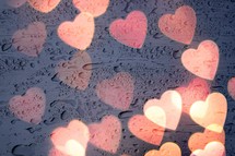 lights of heart shape on the window with drops