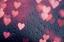 lights of heart shape on the window with drops