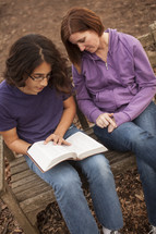 a young man and a woman reading a Bible - mentor 