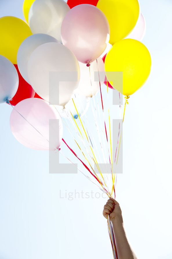hand holding up balloons 