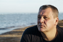 middle-aged man thinking at the beach