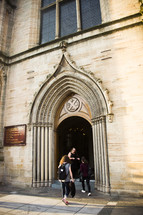 people entering through cathedral doors 