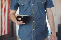 a torso of a man holding a coffee mug 