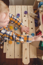 Child building with wooden toys.