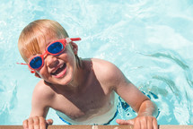 boy child in a swimming pool with goggles 
