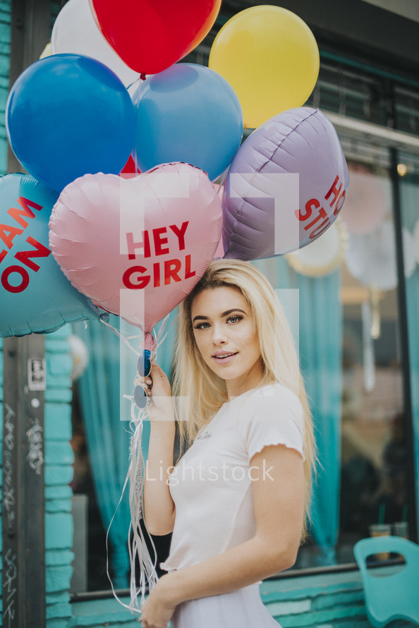 a woman holding balloons 