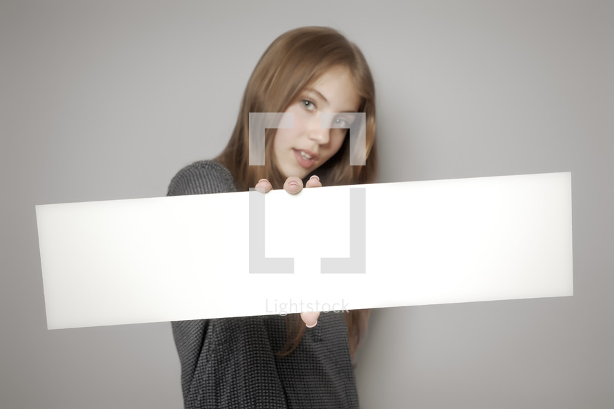 teen girl holding a blank sign 