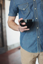 torso of a man holding a mug 