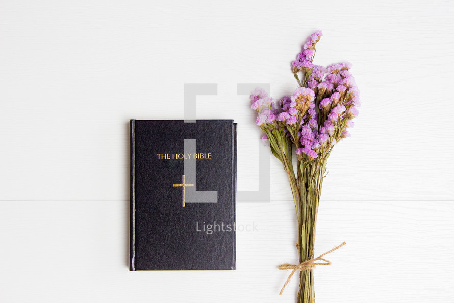Holy Bible and dried flowers on a white background 