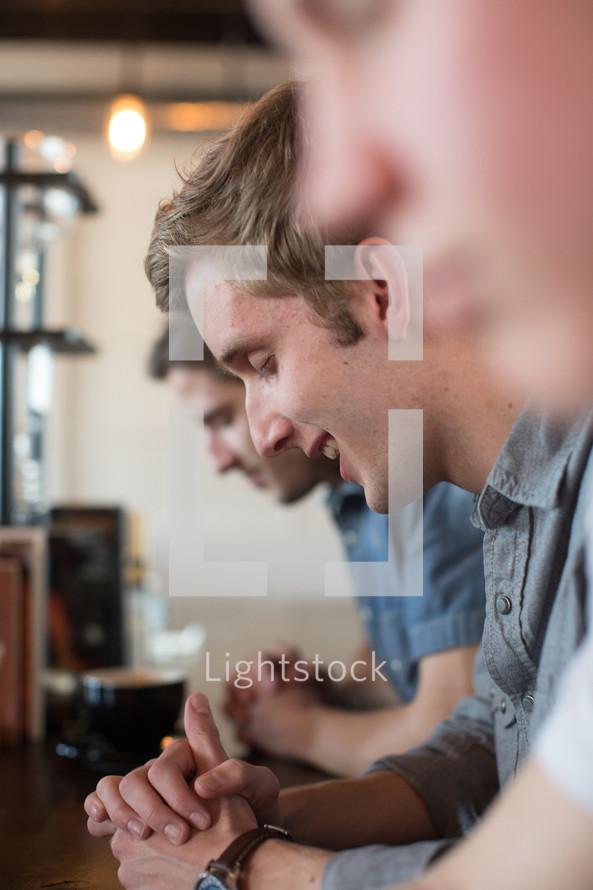 men's prayer group in prayer at a coffee shop 
