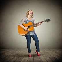 woman playing a guitar on stage