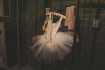 A leotard and tutu hanging on a hanger. 