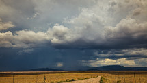 Dark, ominous clouds after a monsoon storm in the desert with rural road