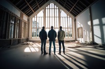 Building for Jesus. Three men standing in front of the window of a church in construction