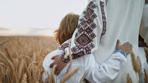 Unrecognizable ukrainian young family in wheat field