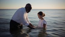 Baptism. A black Pastor baptize a young white girl in the water