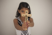 a girl holding up a crucifix 