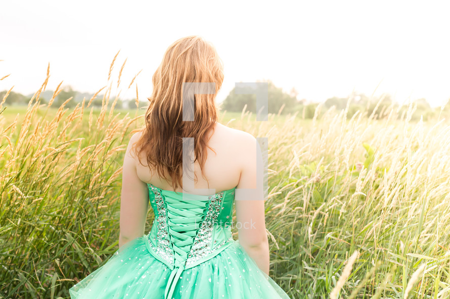 girl in a green prom dress in a field 