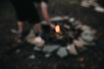 lighting a fire in a fire pit 