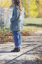 a woman standing alone on a sidewalk 