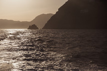 sunlight on the water and cliffs along an Italian shoreline 