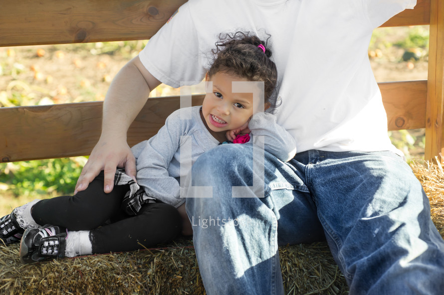 father and daughter on a hay bale