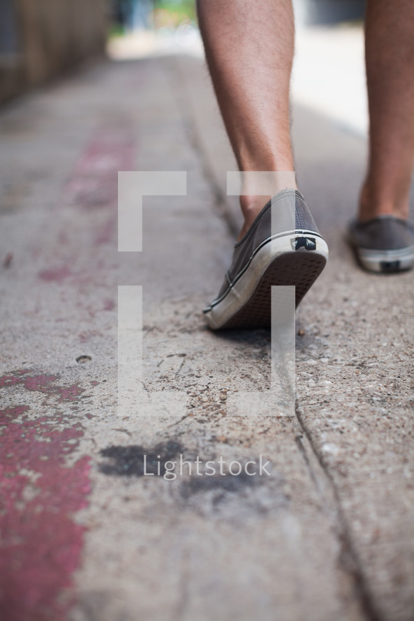 shoes walking on a sidewalk 
