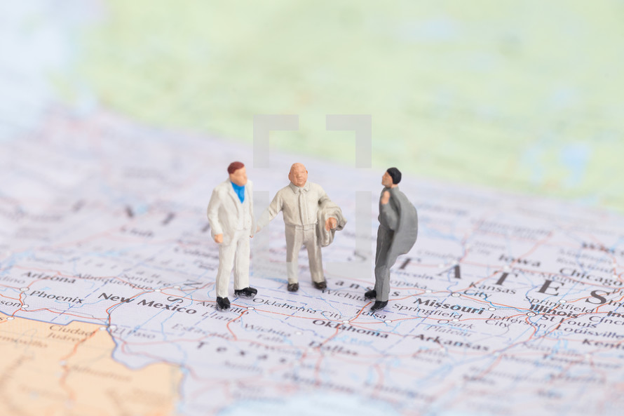 businessmen figurines standing on a map of the United States 