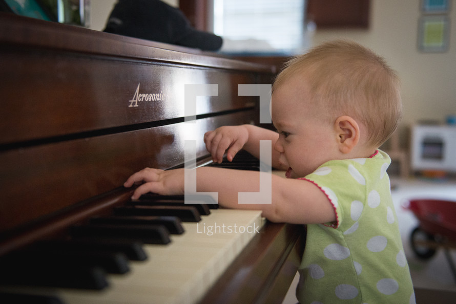 infant playing a piano 