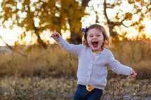 happy toddler girl running outdoors 