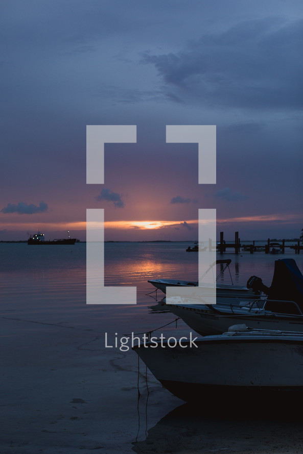 boats on a shore at sunset in the Bahamas 