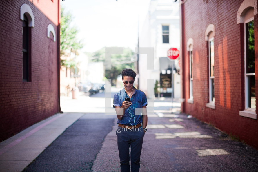 man walking in an alley listening to an iPod 