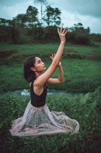 a young woman dancing in a field 