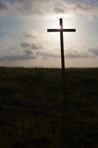sunburst behind a cross silhouette 