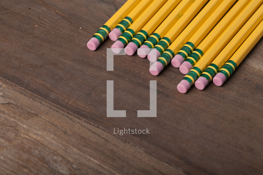 pencils with erasers on a wood table 