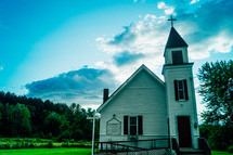 a rural white church with a steeple 