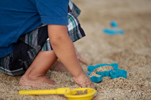 a toddler playing in sand 