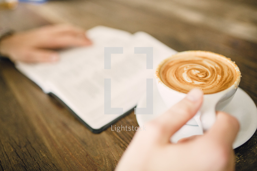 man reading a Bible with a cappuccino 