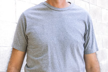 Chest view of a man wearing a blank gray tshirt.