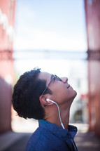 man standing in an alley listening to an iPod 